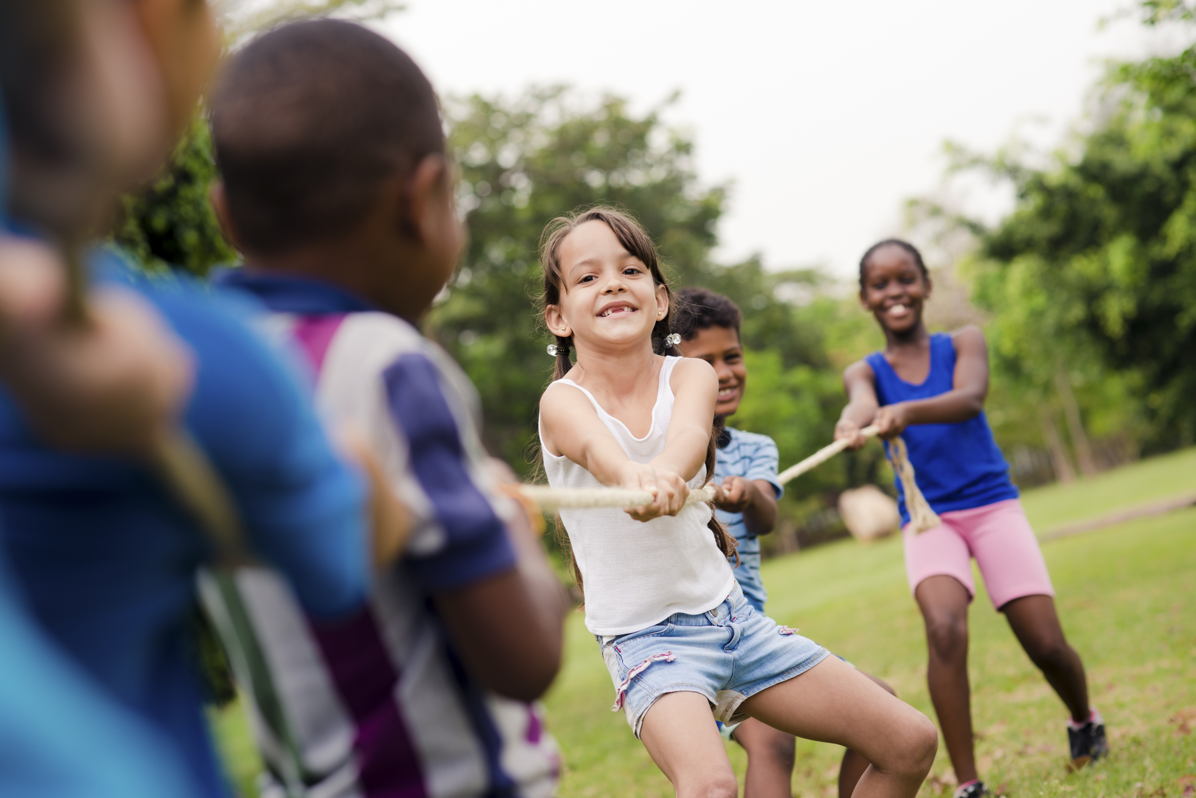 Children playing a game of tug of war outside. 